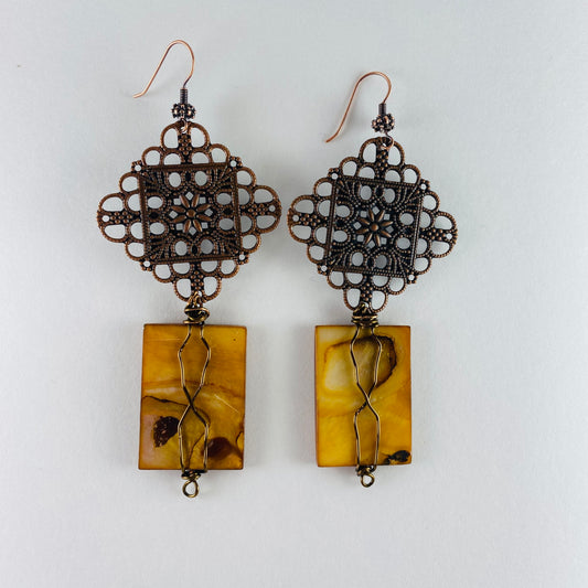 Dangling earrings 2 components.  One filigree focal and one flate amber rectangle glass bead.