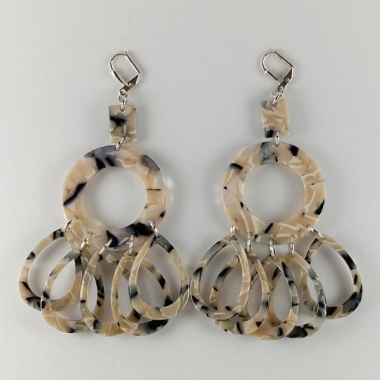 Chandelier earrings with 3 marbled midnight blue beads.  A small rectangle, connected to a round donut with five individual teardrop beads.
