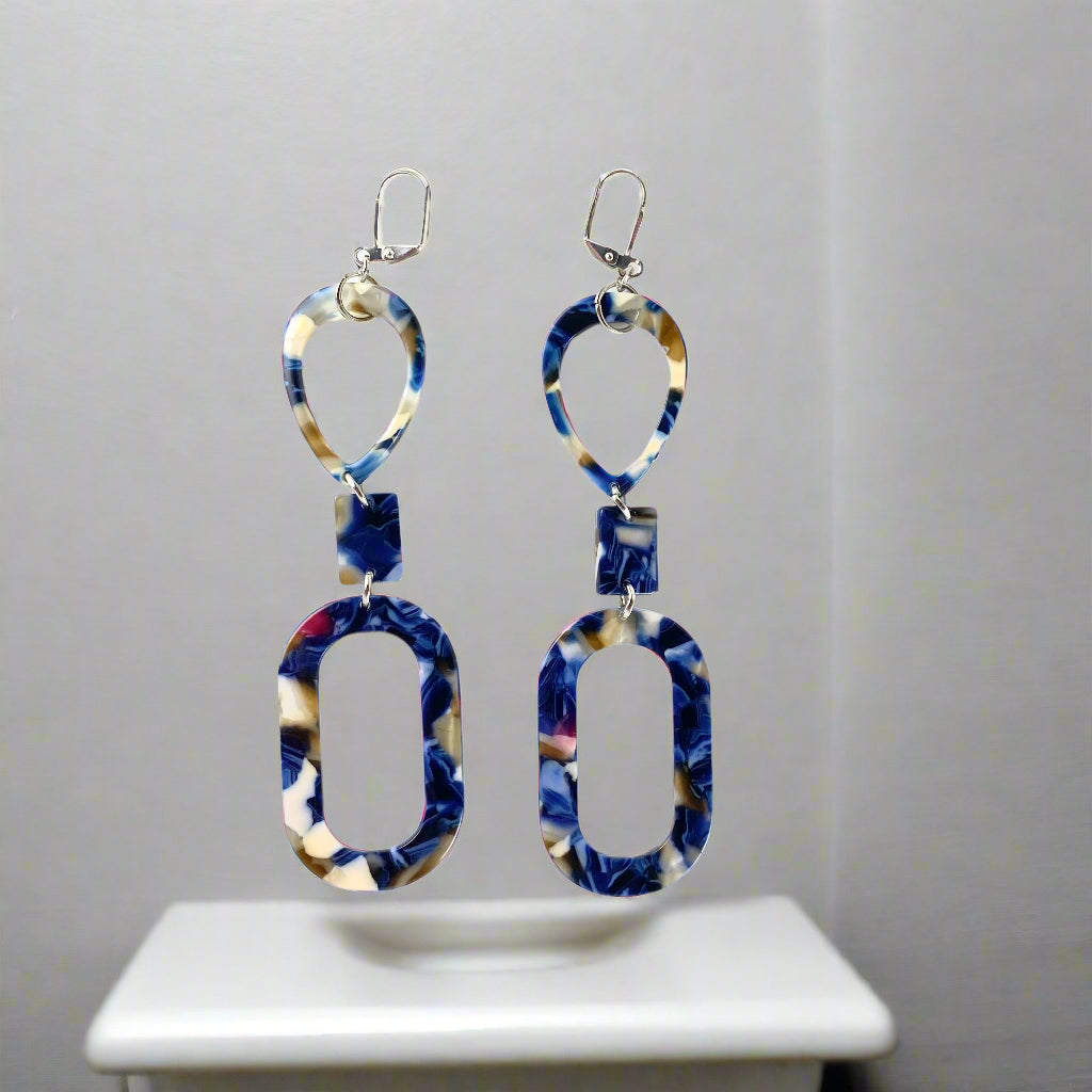 Long dangling earring in 3 marbled parts: a teardrop, a small rectangle and an oval donut.