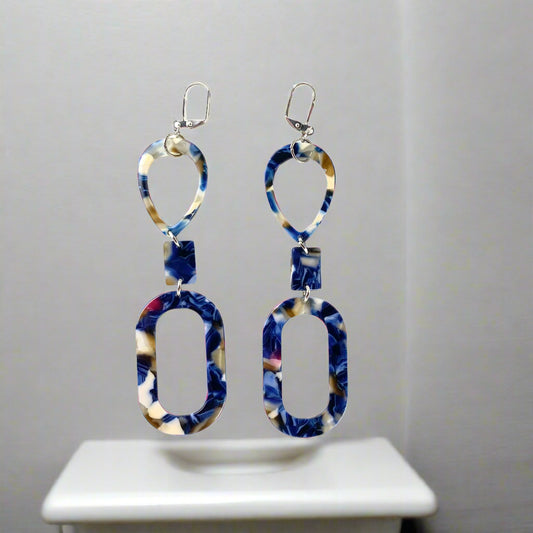 Long dangling earring in 3 marbled parts: a teardrop, a small rectangle and an oval donut.