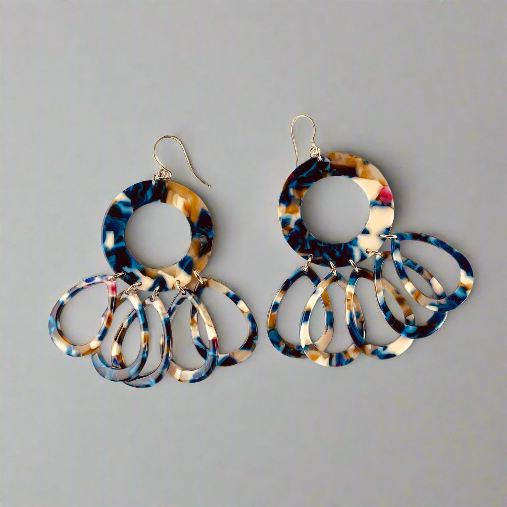 Dangling earring with a mosaic blue, beige,clear and a touch of hot pink.  Comprised of donut shaped bead with 5 teardrop beads.  Also available in honeycomb yellow.