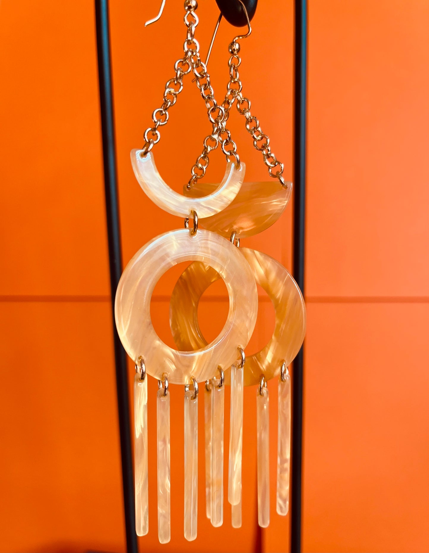 Dangling chandelier earrings with 4 parts: 2 inches of chain, a half moon, and one donut bead with 5 thins rods.  The other earring has a crescent bead instead of a half moon.