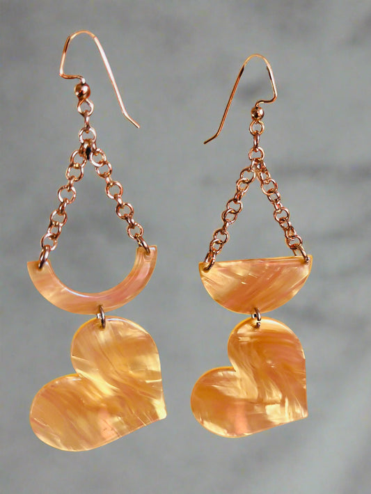 Dangling earring made of acetate with a crescent and half moon shaped beads combined with a heart shaped bead and attached with gold chain.